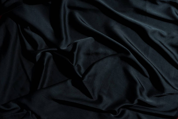 Abstract creatieve achtergrond van verfrommelde textiel stof van zwarte kleur met kopieerruimte. Kan gebruikt worden voor uw creativiteit. - Foto, afbeelding