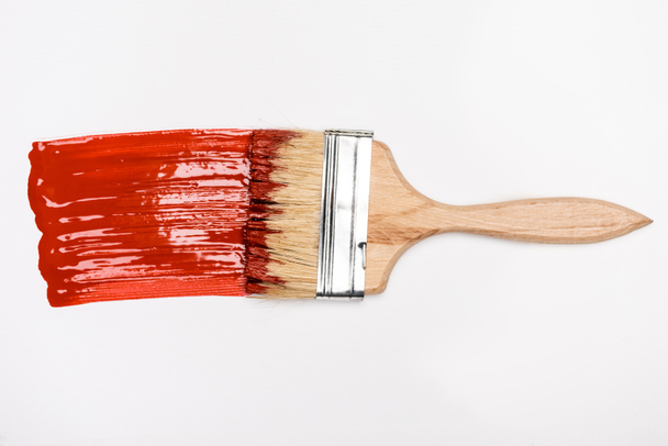 Beyaz arkaplanda kırmızı boya fırçasının yanındaki boya fırçasının üst görünümü - Fotoğraf, Görsel