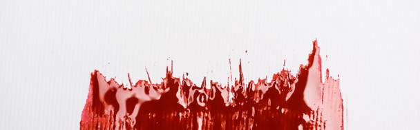 vue de dessus de la peinture rouge colorée coup de pinceau sur fond blanc, vue panoramique - Photo, image