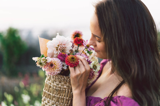 Portrait fille aux cheveux longs avec un panier de fleurs. Promenade dans le jardin fleuri. Fille et fleurs - Photo, image