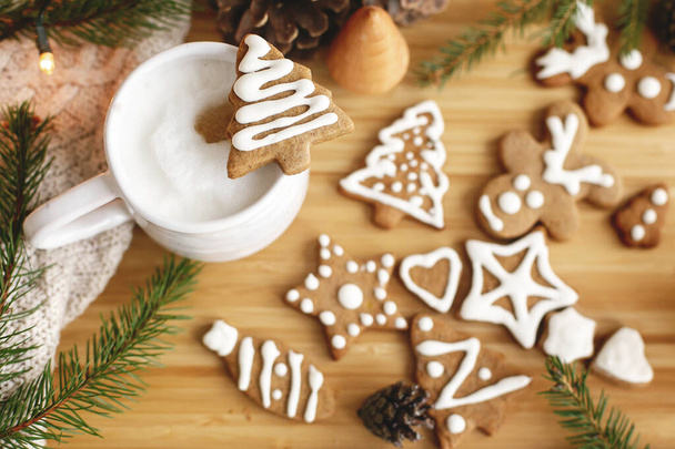 Karácsonyfa mézeskalács süti aromás kávé hátterében fenyőtoboz, fenyő ágak és meleg fények. Helló tél. Boldog karácsonyt és boldog ünnepeket!! - Fotó, kép