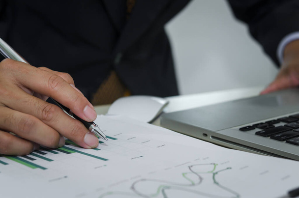 Деловой человек с ручкой, бизнес-документами, отчетами, графиками и графиками финансовой отчетности и ростом прибыли - Фото, изображение