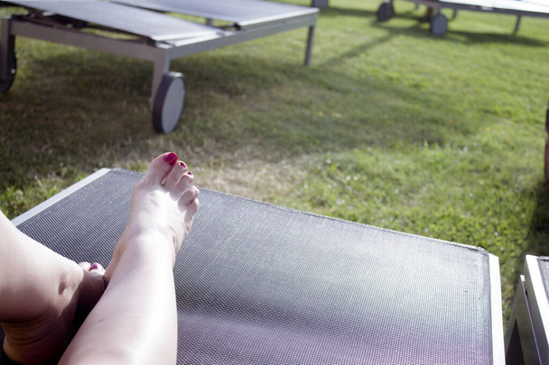 プールラウンジャー日光浴の女性の足。晴れた日 - 写真・画像