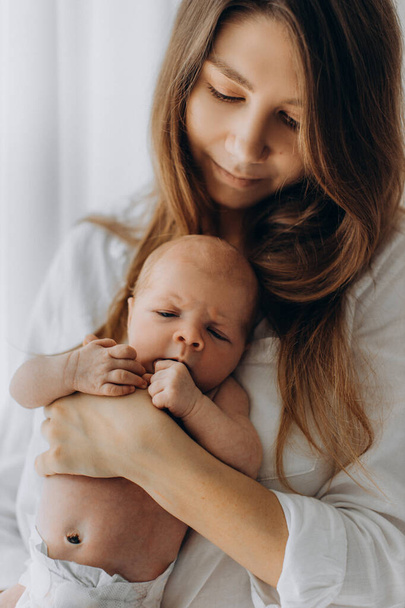 Mujer bonita sostener hermosa niña recién nacida en brazos, mamá feliz disfrutar de momentos tiernos con hija pequeña, sonriente, maternidad y el concepto de crianza - Foto, imagen