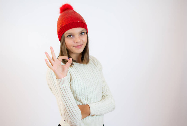 Young caucasian girl isolated on white background showing okay sign with fingers - Фото, изображение