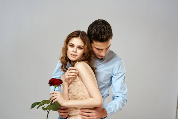 Cheerful young couple romance embrace relationship red rose lifestyle light background - Photo, Image