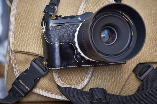 Фотография; цифровая камера без зеркала с объективом и сумкой для камеры - Фото, изображение