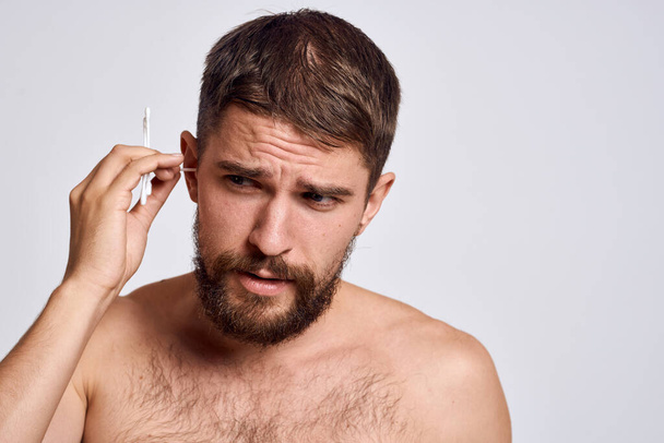 Bearded man with bare shoulders cotton swabs hygiene body care - Photo, image