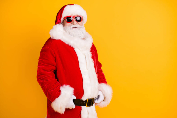 Portrait of his he nice funny confident serious white-haired Santa holding belt wearing winter warm fluffy look outfit garment isolated bright vivid shine vibrant yellow color background - Foto, Bild