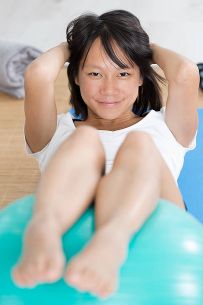 woman doing abdominal exercises on an aerobic ball - Fotó, kép