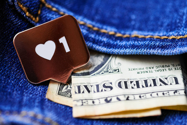 Символ сердца и доллар в кармане джинсов. Кнопка подписи, символ с сердцем и цифрой. Маркетинг социальных сетей. - Фото, изображение