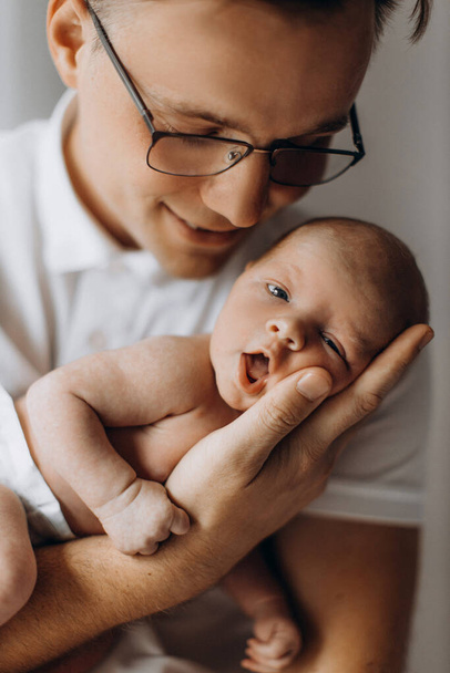 Caring dad with lovely newborn baby girl, loving father hold in arms beautiful little daughter, enjoy tender parenting moments, smiling, fatherhood and childhood concept - 写真・画像