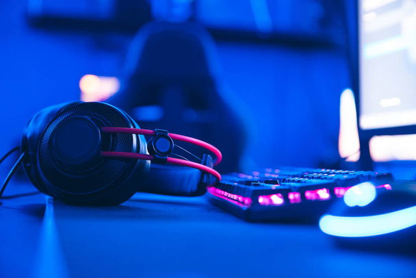 Tietokonepelaaja työpaikalla uuden pelin hiiri ja näppäimistö hämärtää vaaleanpunainen neon valo tausta - Valokuva, kuva