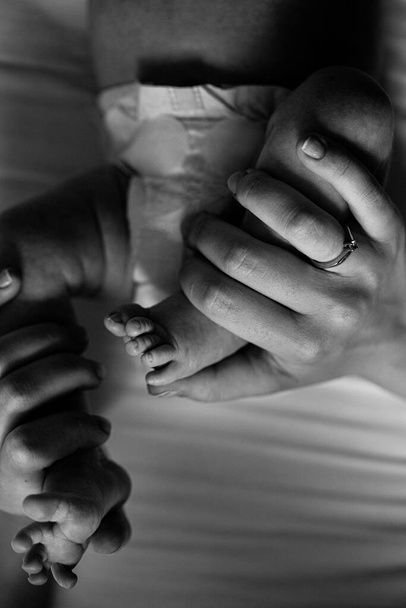 Portrait of adorable little legs with tiny fingers, of lovely newborn baby girl, in caring parent arms, happy family moments, birth and childhood concept - Foto, immagini