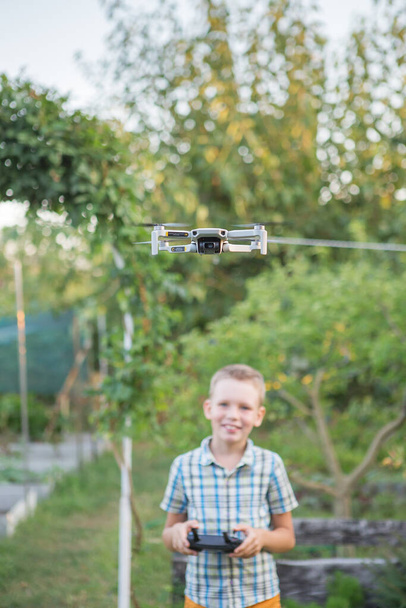 Kinderfliegerdrohne. Junge bedienen Drohnen. Kinderbetriebener Quadrocopter. Kleiner Pilot mit Drohnen-Fernbedienung - Foto, Bild