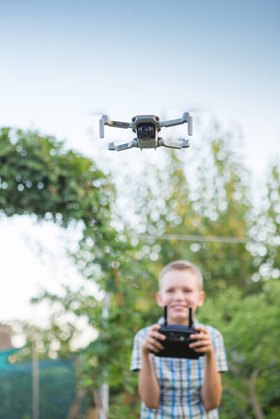 Un drone volant. Un garçon opère des drones. Enfant opérant Quadcopter. Petit pilote utilisant une télécommande par drone - Photo, image