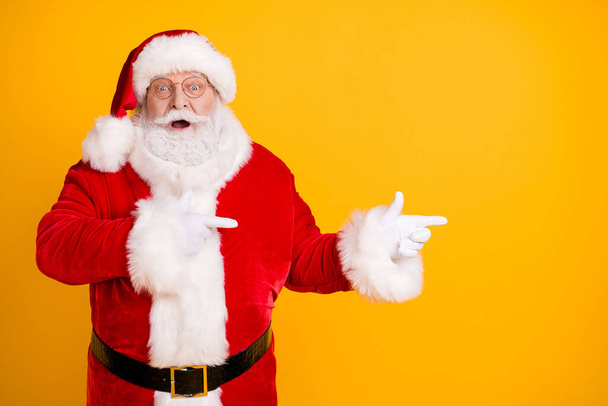 Photo astonished beard santa claus impressed x-mas noel christmas adverts discount point finger copyspace wear cap headwear style stylish trendy costume isolated bright shine color background - Foto, Bild