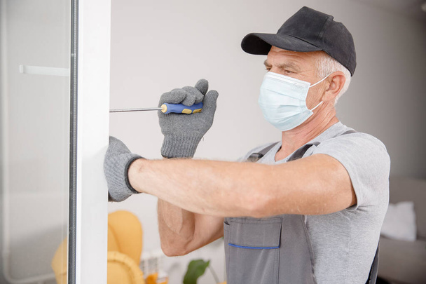 Εργαζόμενος άνθρωπος εγκαθιστά πλαστικά παράθυρα και πόρτες με διπλά τζάμια λευκό - Φωτογραφία, εικόνα