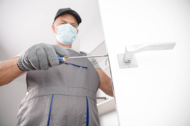 Az orvosi maszkos munkások szilikon csövet használnak az ablak javítására és beszerelésére. Koncepciószerviztechnikus - Fotó, kép