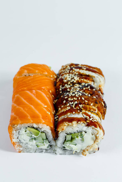 Sushi választék. Sushi tekercs avokádóval, uborkával. Sushi tekercs lazaccal és kaviárral. Sushi tekercs tonhallal és kaviárral. Fényes háttérrel. Japán kaja. Kilátás felülről - Fotó, kép
