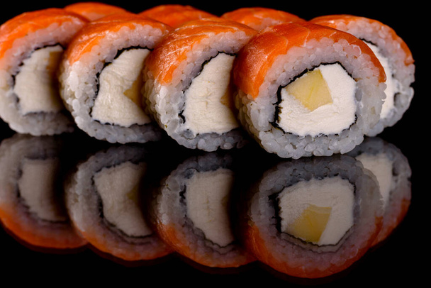 Φρέσκα νόστιμα όμορφα ρολά σούσι σε σκούρο φόντο. Στοιχεία της ιαπωνικής κουζίνας - Φωτογραφία, εικόνα