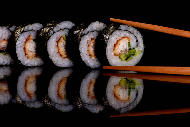 Fresh delicious beautiful sushi rolls on a dark background. Elements of Japanese cuisine - Photo, Image