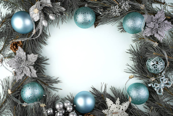 Beautiful Christmas frame in art processing with blue and silver toys on a blue background. - Foto, afbeelding