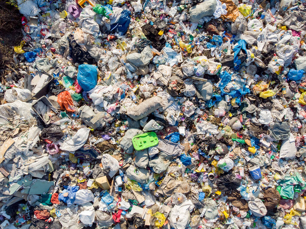 Plastik şişeler ve poşetlerle kara kirliliği. Katı atıkların depolandığı yeri aç. Havadan üst görünüm - Fotoğraf, Görsel