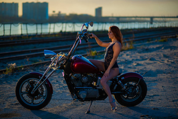 Red-haired woman in sexy lingerie in high heels sits on a motorcycle - Φωτογραφία, εικόνα