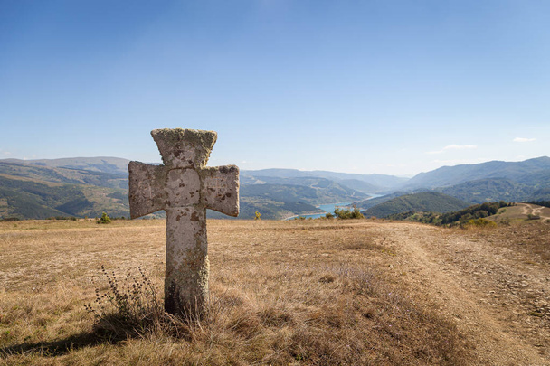 Sehr altes Betonkreuz auf dem Aussichtspunkt des sich schlängelnden Zavoj-Sees in der Nähe des beliebten Aussichtspunktes Smilovica - Foto, Bild