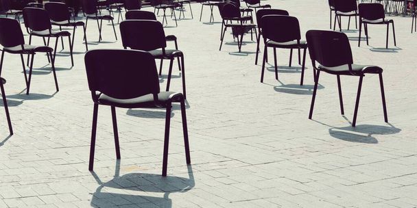 Les chaises dans la rue sont disposées en rangées à distance, gardez vos distances, mesures de quarantaine, préparation d'une conférence, un concert - Photo, image