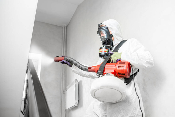 Especialista en trajes blancos limpiando células desinfectantes coronavirus epidemia, virus claro pandemia en el hogar - Foto, Imagen