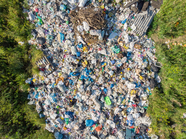 Land pollution with plastic bottles and bags. Open storage of solid waste garbage. Aerial top view - Photo, Image