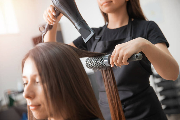Primer plano de secador de pelo y cepillo, concepto corte peluquería estilista femenina - Foto, imagen