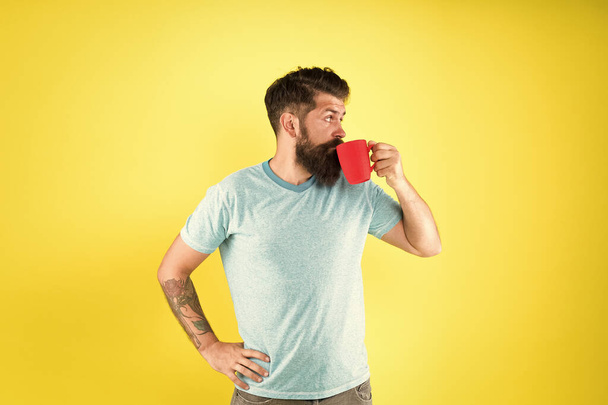 Hipster tastes and aesthetics. Energy concept. Hipster barista yellow background. Coffee shop. Bearded man drink morning coffee. Tea time. Cortado with right proportion of milk. Coffee revolution - Photo, image