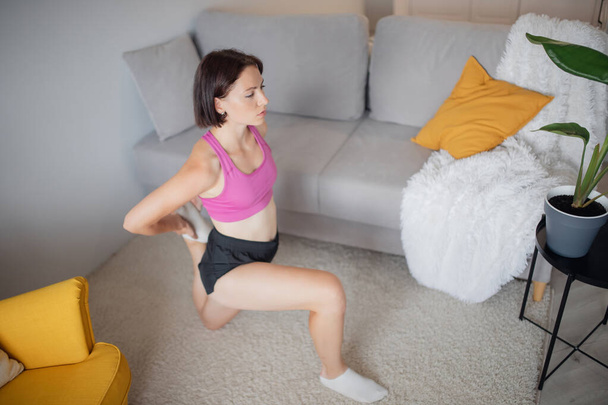 Tyttö treenaa kotona kunto harjoituksia rentoutumista jooga sisätiloissa. Käsite urheilu elämäntapa - Valokuva, kuva