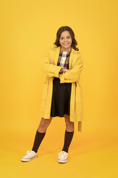 Trendy trench. Classy style. Girl adorable stylish modern teenager. Cool schoolgirl. Charismatic girl on yellow background. Fashion concept. Elegant little schoolgirl. Fashionable schoolgirl - Photo, image