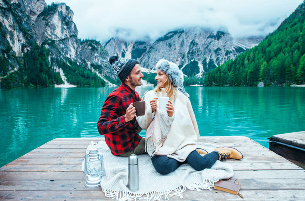 Mountain stories. Happy couple on a wanderlust vacation. Boyfriend and girlfriend spending time together at the lake. Storytelling concept about lifestyle and winter travels - Fotó, kép