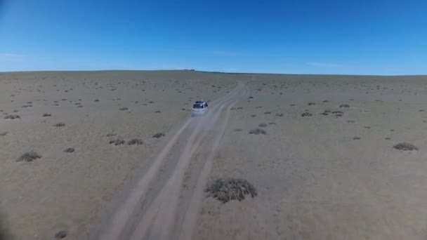 Disparo aéreo de un dron tras una furgoneta en el desierto de Mongolia. - Imágenes, Vídeo
