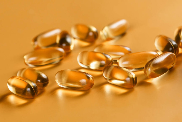 Many capsules Omega 3 on yellow background. Close up. Health care concept. - Foto, afbeelding
