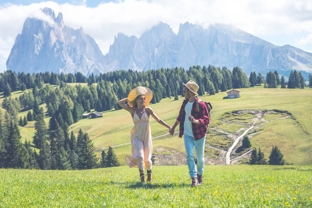Onnellinen pari lomalla Italian dolomiitit vuorilla. Nuori mies ja nainen tekevät toimintaa kauniilla vihreällä niityllä - Valokuva, kuva