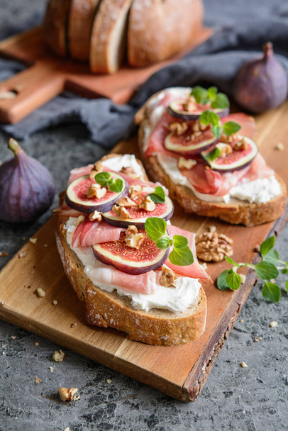Sandwich with goat cheese spread, prosciutto, figs and chopped walnuts - Photo, Image