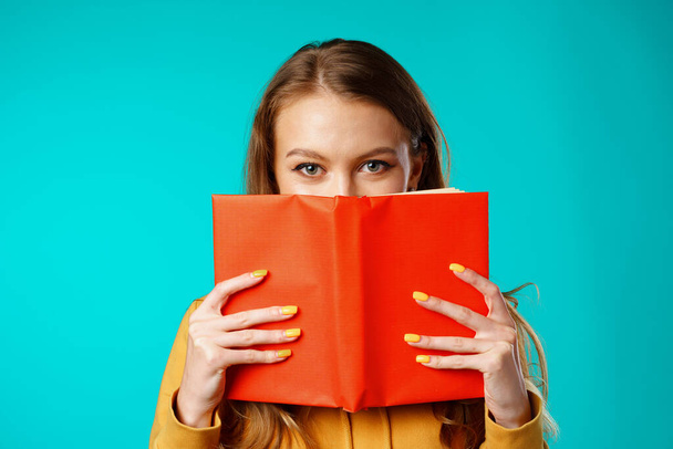 Young woman student hiding her face behind the book - Foto, Bild