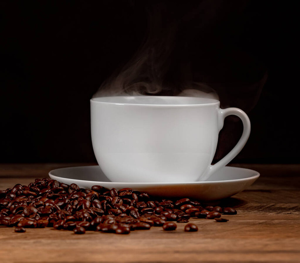 Čerstvě uvařený šálek kávy s kávovými zrny. - Fotografie, Obrázek