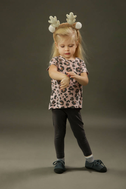 Studio shot van 3 jaar oud fashionable kind op de grijze achtergrond - Foto, afbeelding