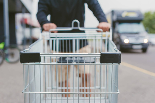 Guy with a supermarket trolley in his hands - Fotoğraf, Görsel