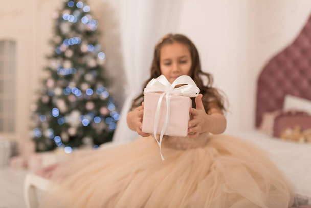 Happy childhood, magical Christmas tale. Little princess with Santa's present for Christmas. - Valokuva, kuva
