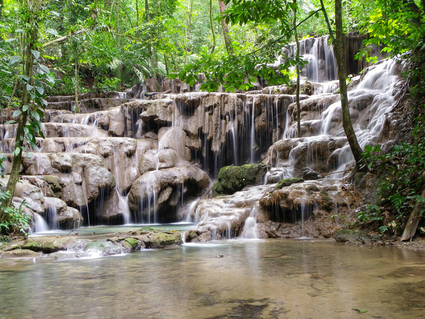 Маленький водопад, украшенный каменными ступенями и множеством растительности вокруг в Паленке, Чьяпас / Мексика - Фото, изображение