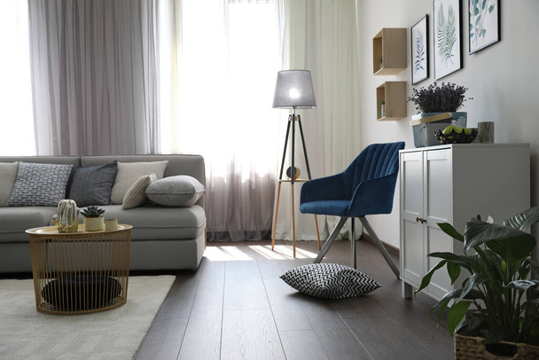 Elegant living room with comfortable sofa and armchair near window. Interior design - Fotoğraf, Görsel