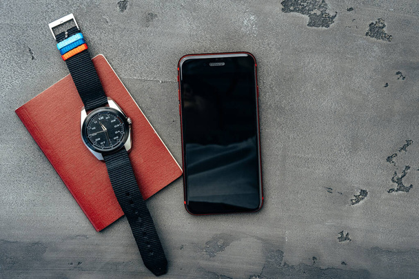 Mens accessories such as smartphone and watch on dark grey table - Fotó, kép